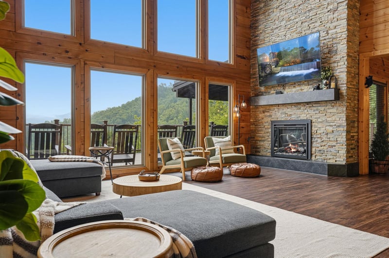 Sink into plush seating beside your stone fireplace and soak in sweeping mountain views through soaring windows—your perfect retreat for peaceful mornings and cozy evenings.