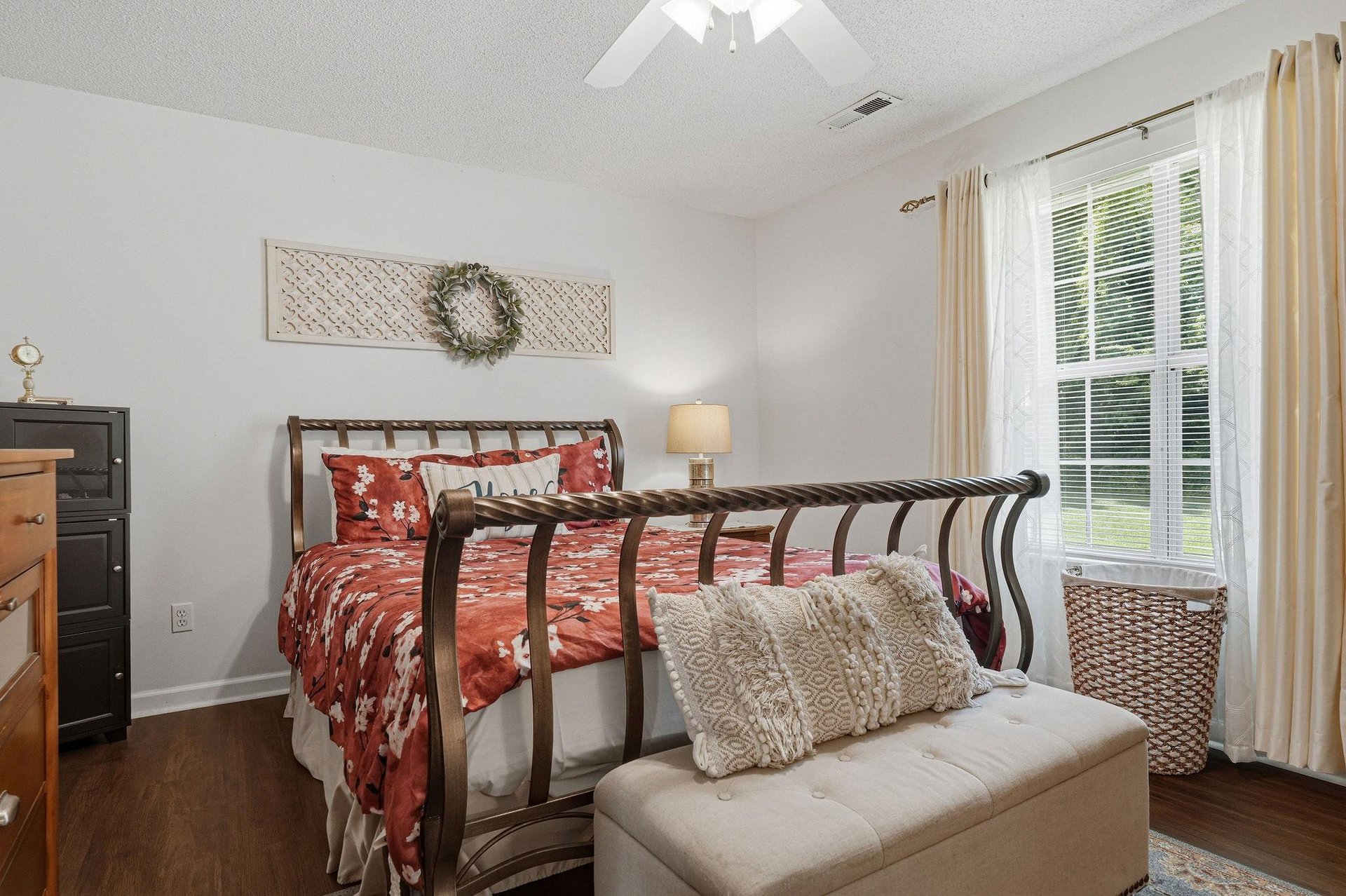 Drift off to sleep in this serene bedroom with its elegant metal bed, soft linens, and natural light streaming through plantation shutters—your personal haven awaits.