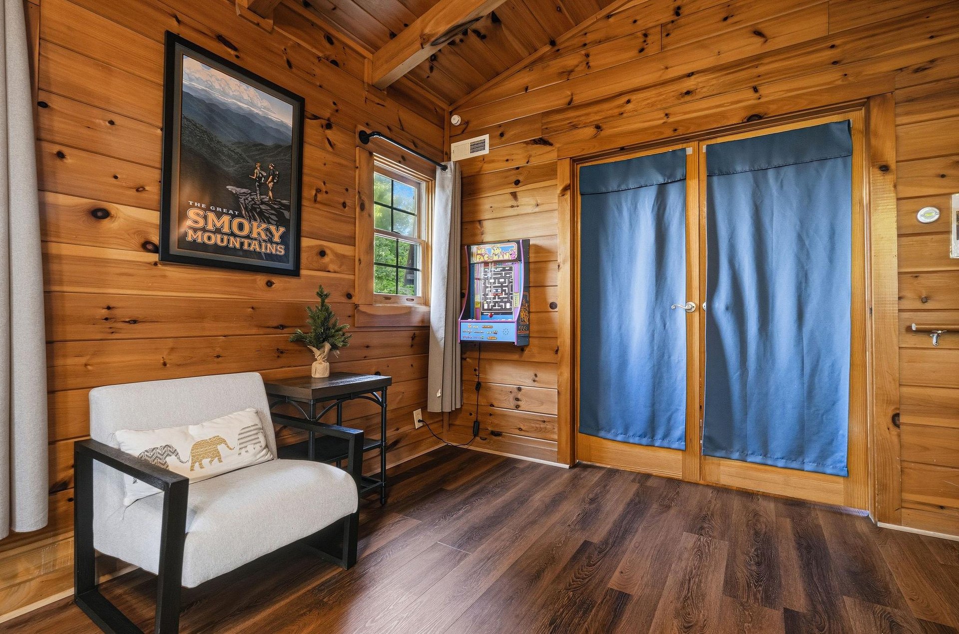 Sink into rustic mountain charm in your cozy living space with warm wood walls and comfortable seating.