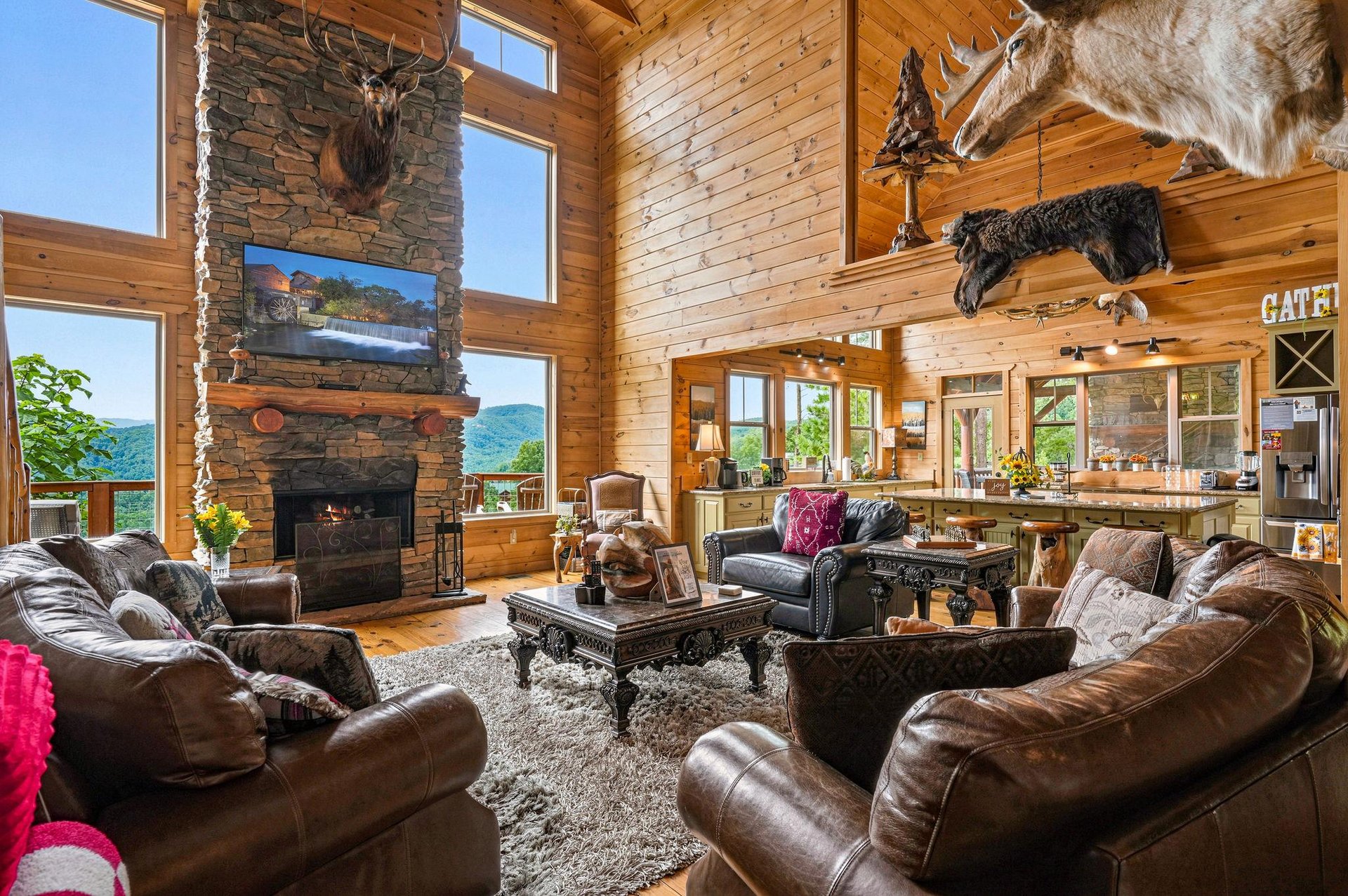 Gather around the stone fireplace in this soaring great room with mountain views stretching beyond the floortoceiling windows. Rich leather seating and rustic elegance create your perfect mountain r