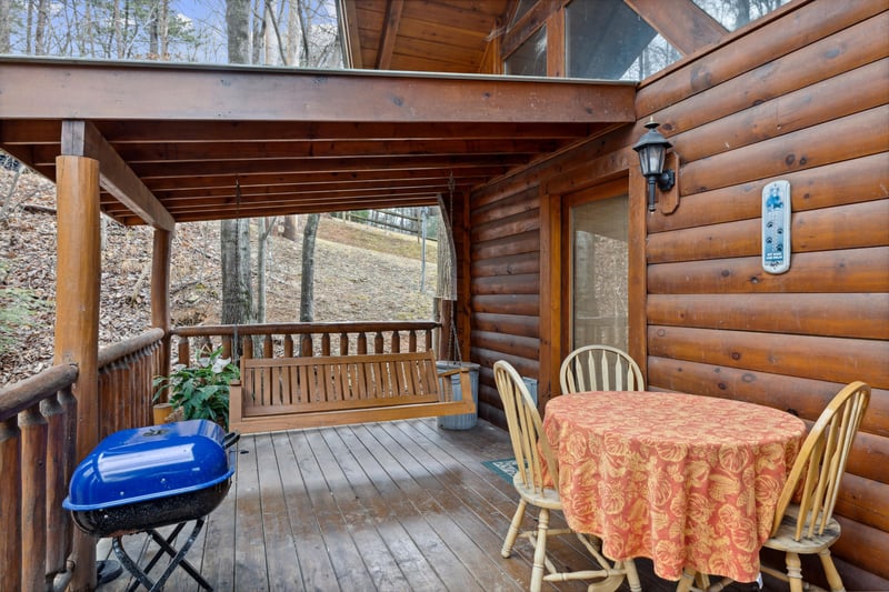 Dining space for three on the deck at Dreams Do Come True, a 1bedroom cabin rental located in Pigeon Forge