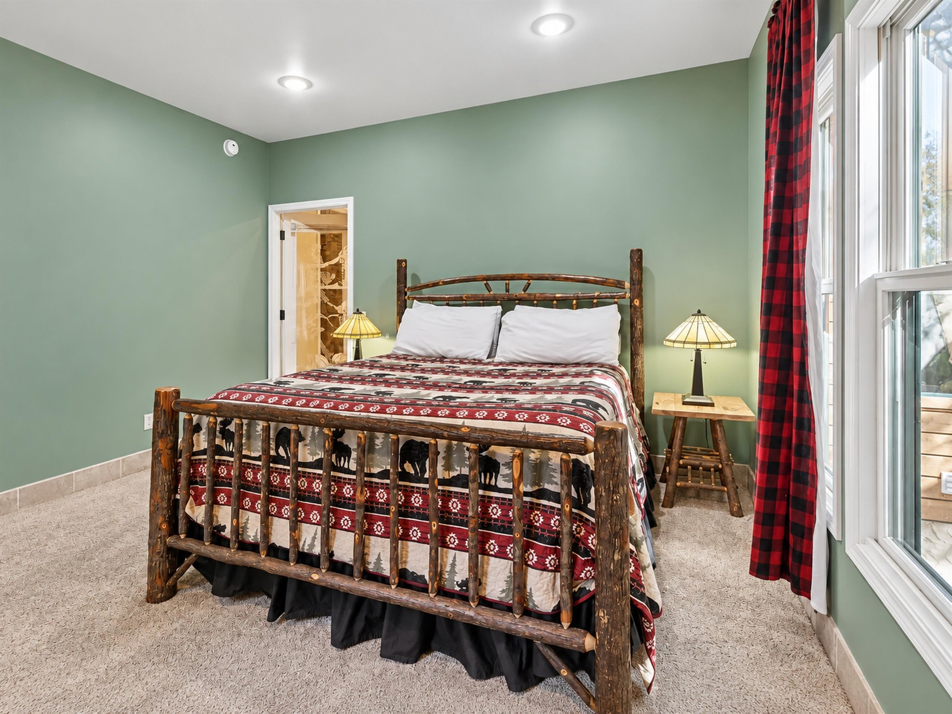 Unwind in your peaceful rustic retreat, where handcrafted log furniture and warm plaid accents create the perfect cabin getaway. Soft sage walls and cozy linens invite restful nights after your mounta