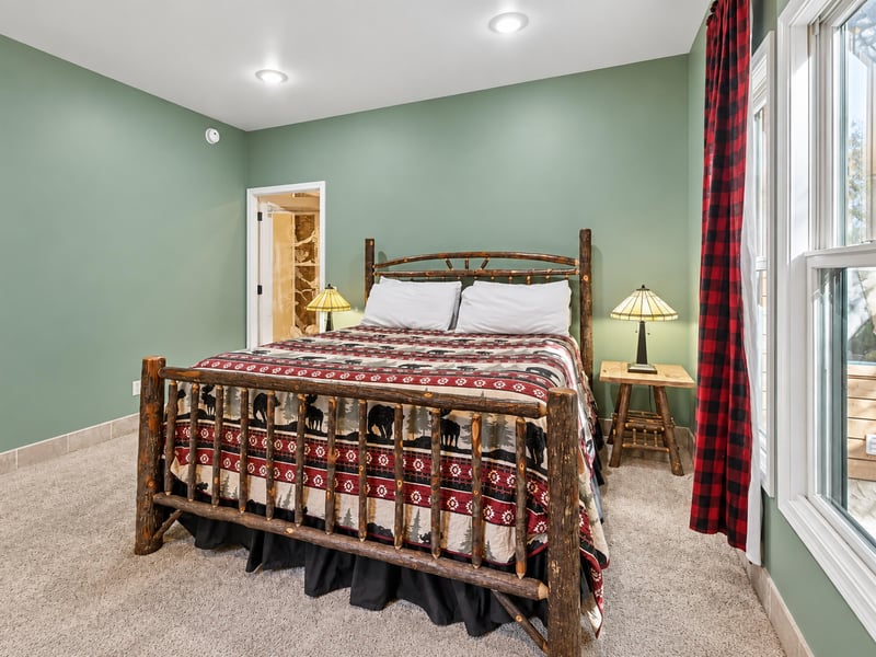 Unwind in your peaceful rustic retreat, where handcrafted log furniture and warm plaid accents create the perfect cabin getaway. Soft sage walls and cozy linens invite restful nights after your mounta