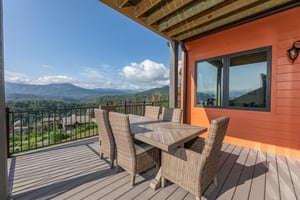 Dining space on the deck at Mountain Celebration, a 4 bedroom cabin rental located in Gatlinburg