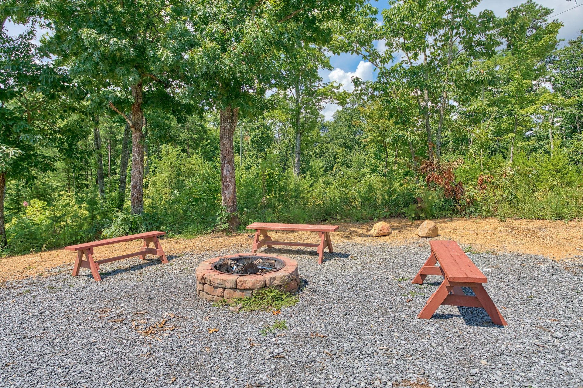 Fire pit with three benches at Four Seasons Lodge, a 3bedroom cabin rental located in Pigeon Forge