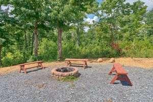 Fire pit with three benches at Four Seasons Lodge, a 3bedroom cabin rental located in Pigeon Forge