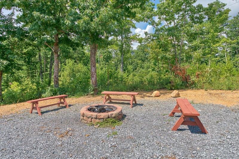 Fire pit with three benches at Four Seasons Lodge, a 3bedroom cabin rental located in Pigeon Forge