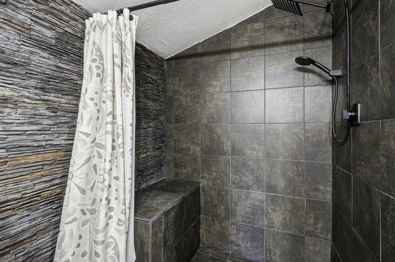 Unwind in your private spalike shower with stunning stone walls, natural textures, and modern fixtures creating pure relaxation.