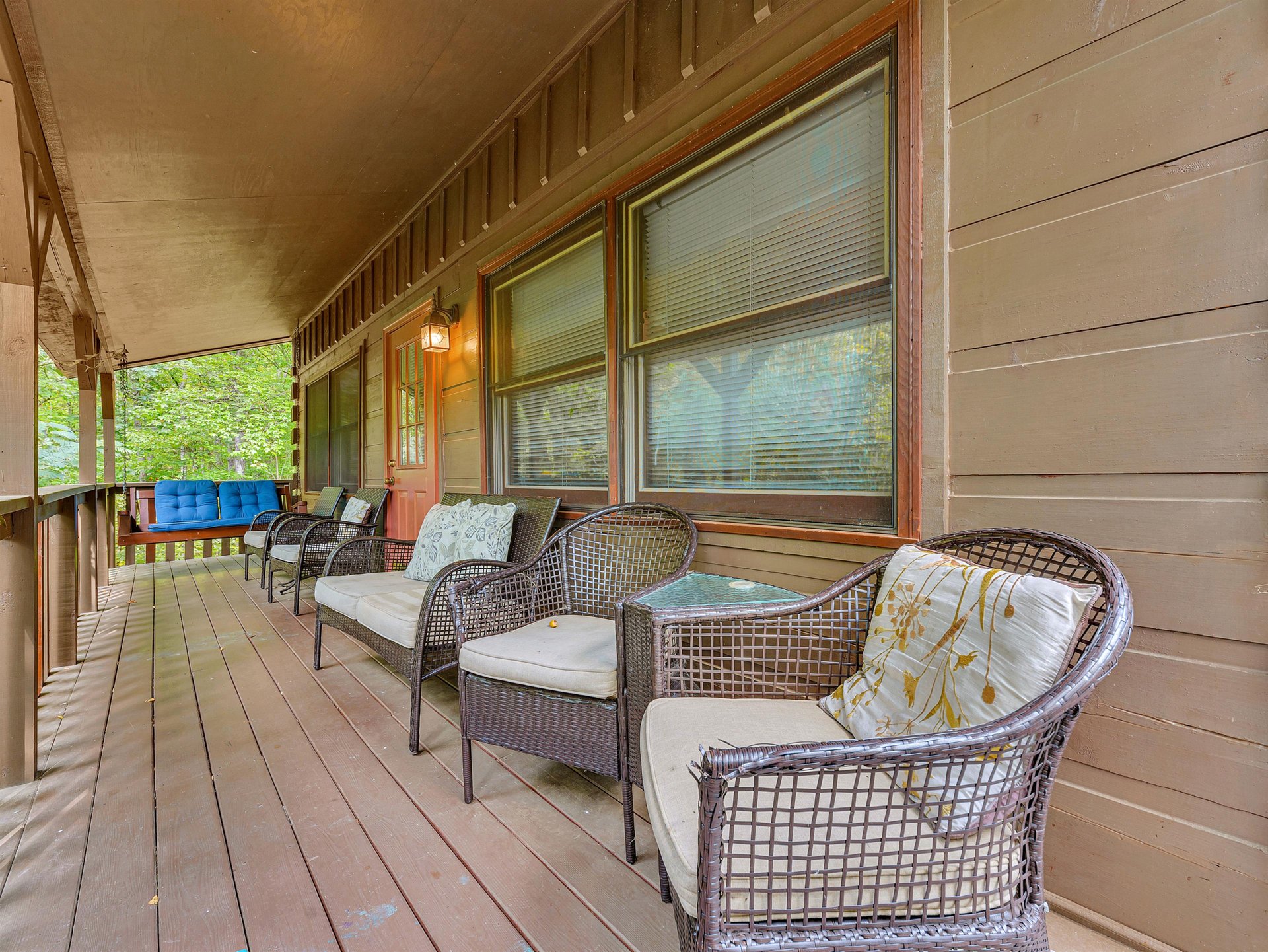 Unwind on your private wraparound porch with comfortable seating surrounded by peaceful forest views.