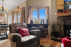 Settle into your cozy chair by the crackling fireplace while mountain views frame your perfect alpine retreat.