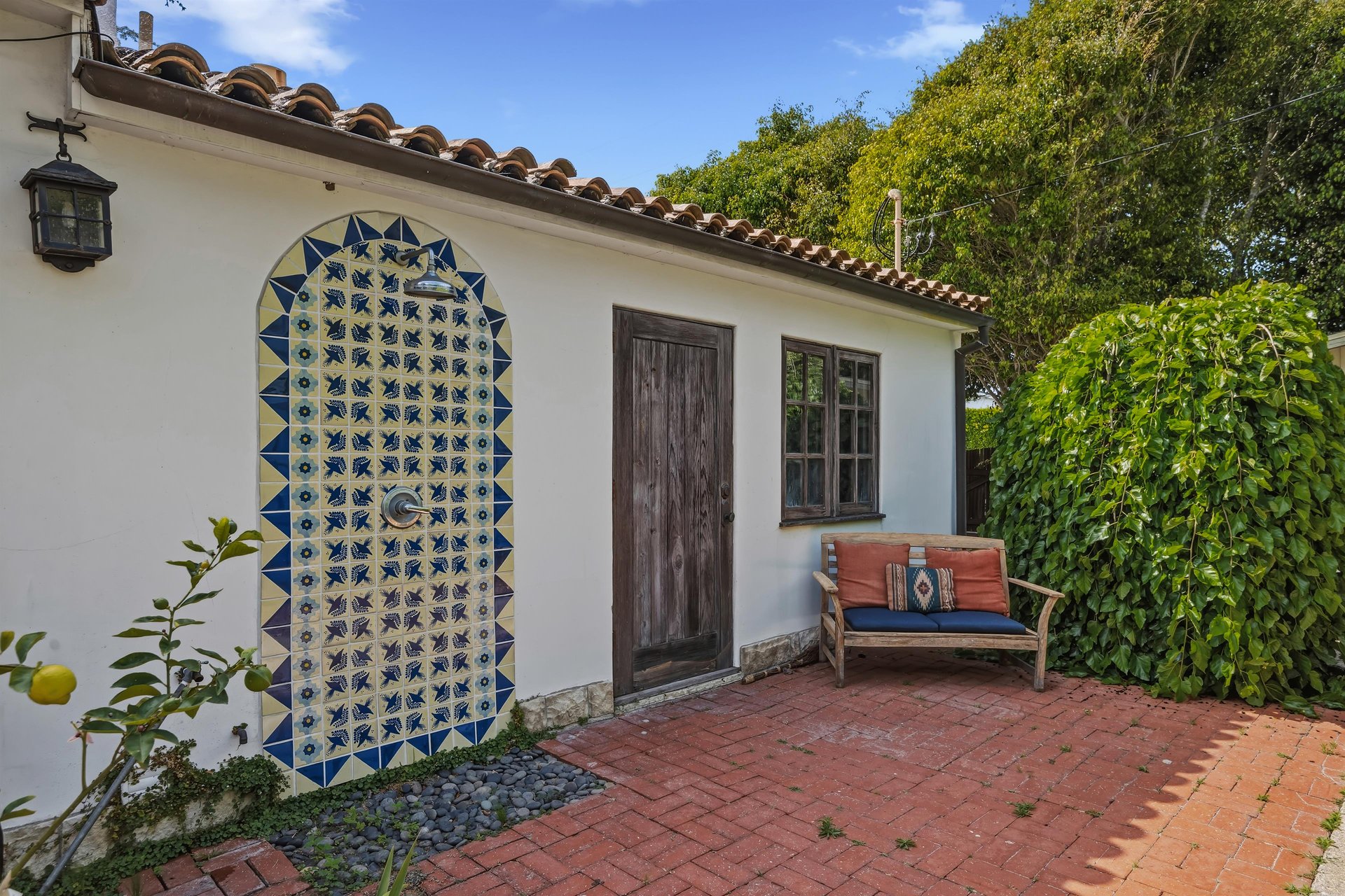 Stunning patio with mosaic tiles, outdoor seating, and an outdoor shower.