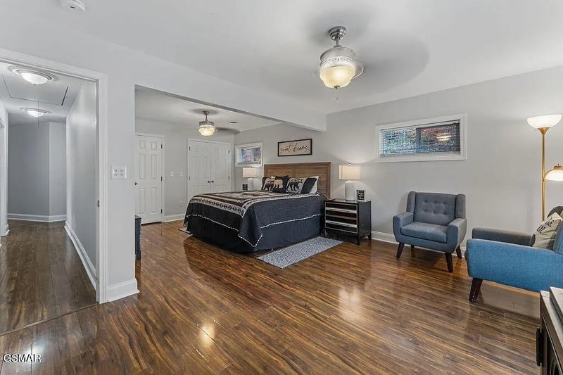 Unwind in your spacious master suite with polished hardwood floors, cozy seating area, and warm ambient lighting creating the perfect retreat.