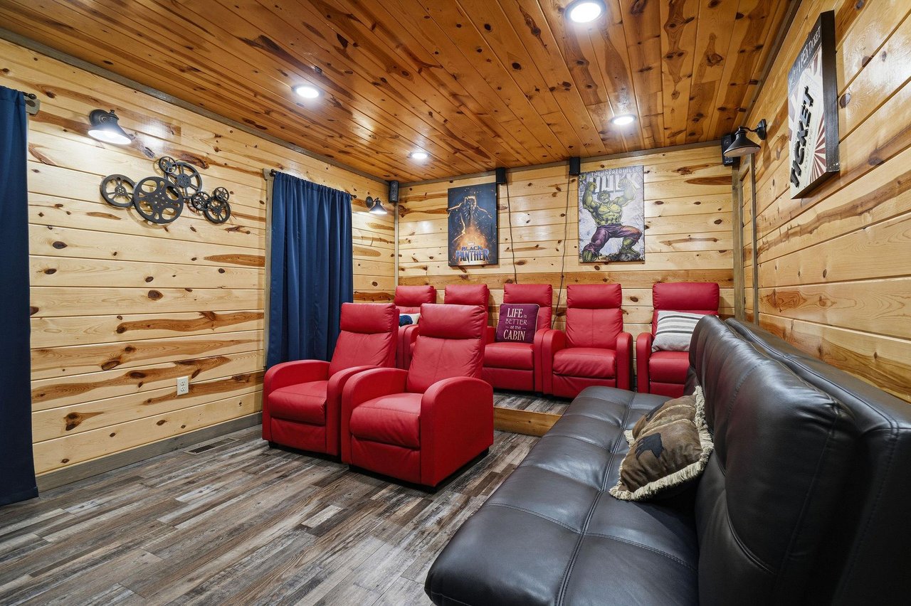 Relax in your private theater with plush red recliners and cozy leather seating for the perfect movie night experience.