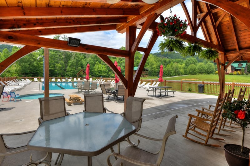 The covered pavilion overlooks a sparkling pool and lush mountain scenery, offering a perfect spot to relax and take in the peaceful resort grounds.