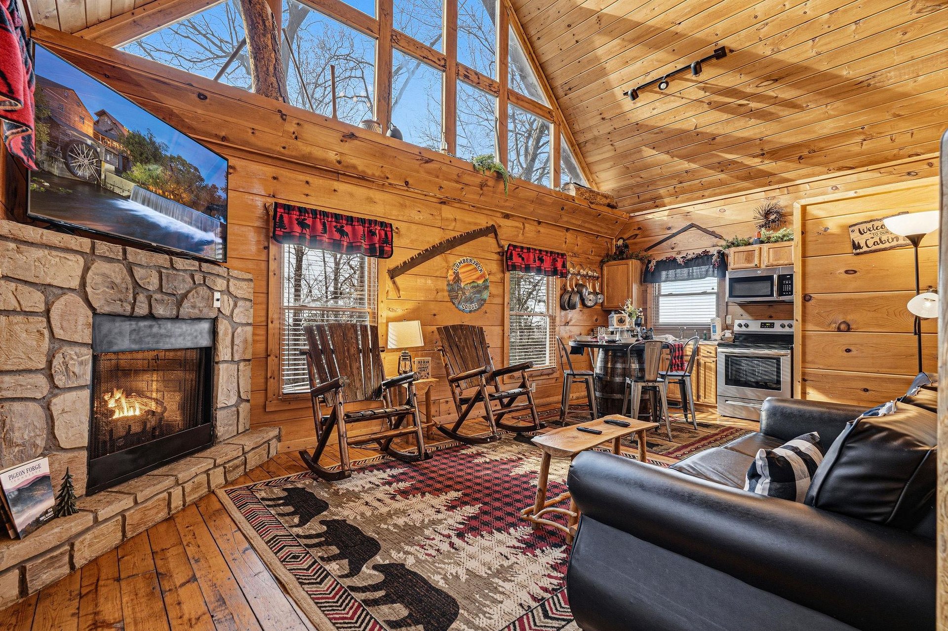 Cozy up in your rustic cabin retreat, where crackling fireplace warmth meets modern comfort beneath soaring woodbeam ceilings.