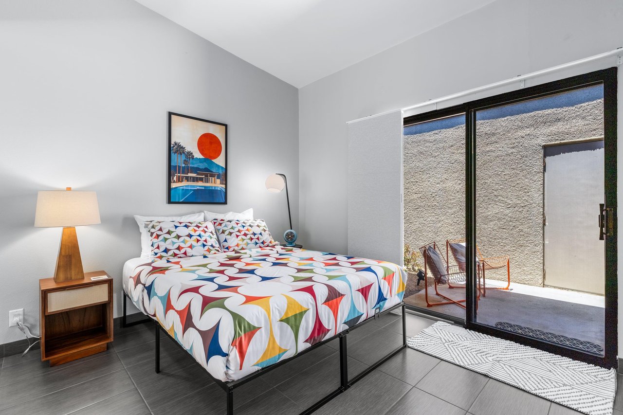 Queen size bed, desk space, and front patio access.