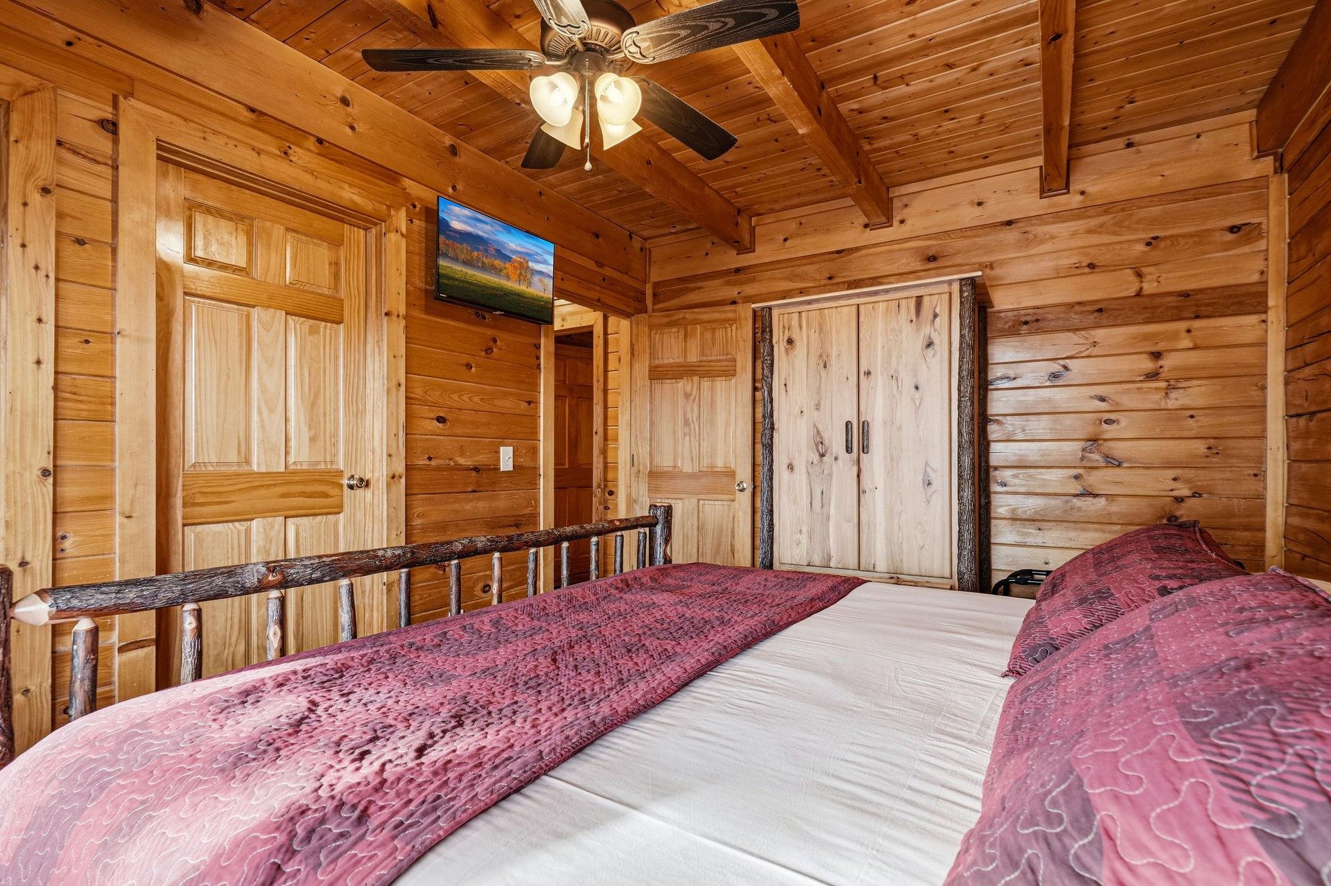 Drift to sleep in your rustic log cabin bedroom, where warm cedar surrounds you and a gentle ceiling fan whispers overhead.