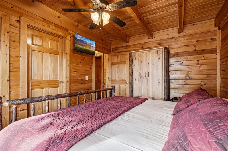Drift to sleep in your rustic log cabin bedroom, where warm cedar surrounds you and a gentle ceiling fan whispers overhead.
