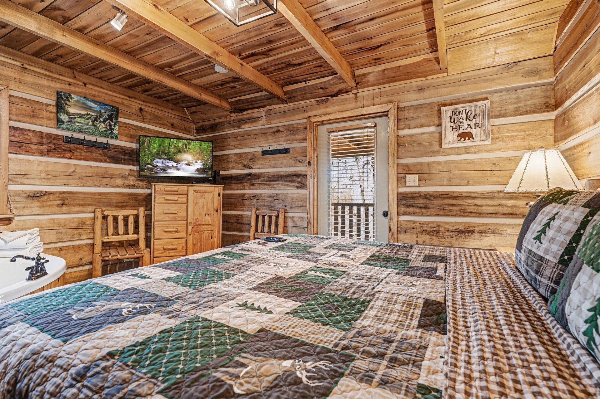 Wake up in your cozy log cabin bedroom with rustic charm, plaid bedding, and mountain views from your window.