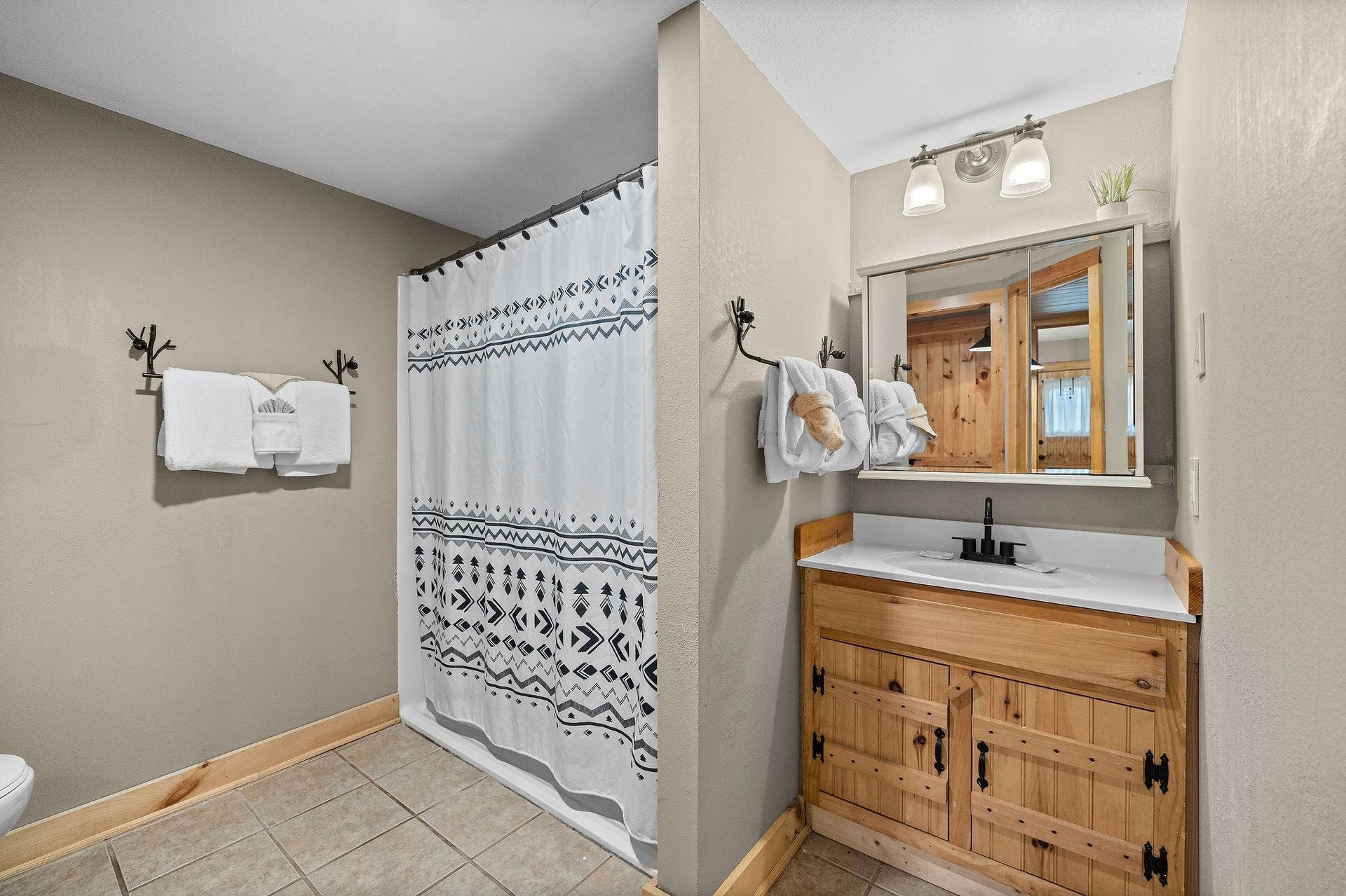 Single vanity sink with divider wall to shower