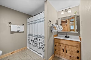 Single vanity sink with divider wall to shower
