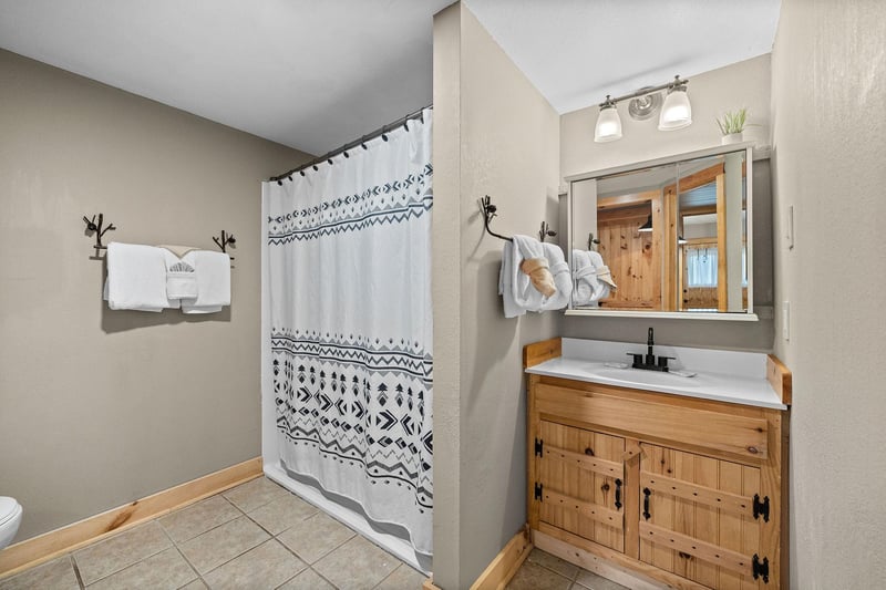 Single vanity sink with divider wall to shower