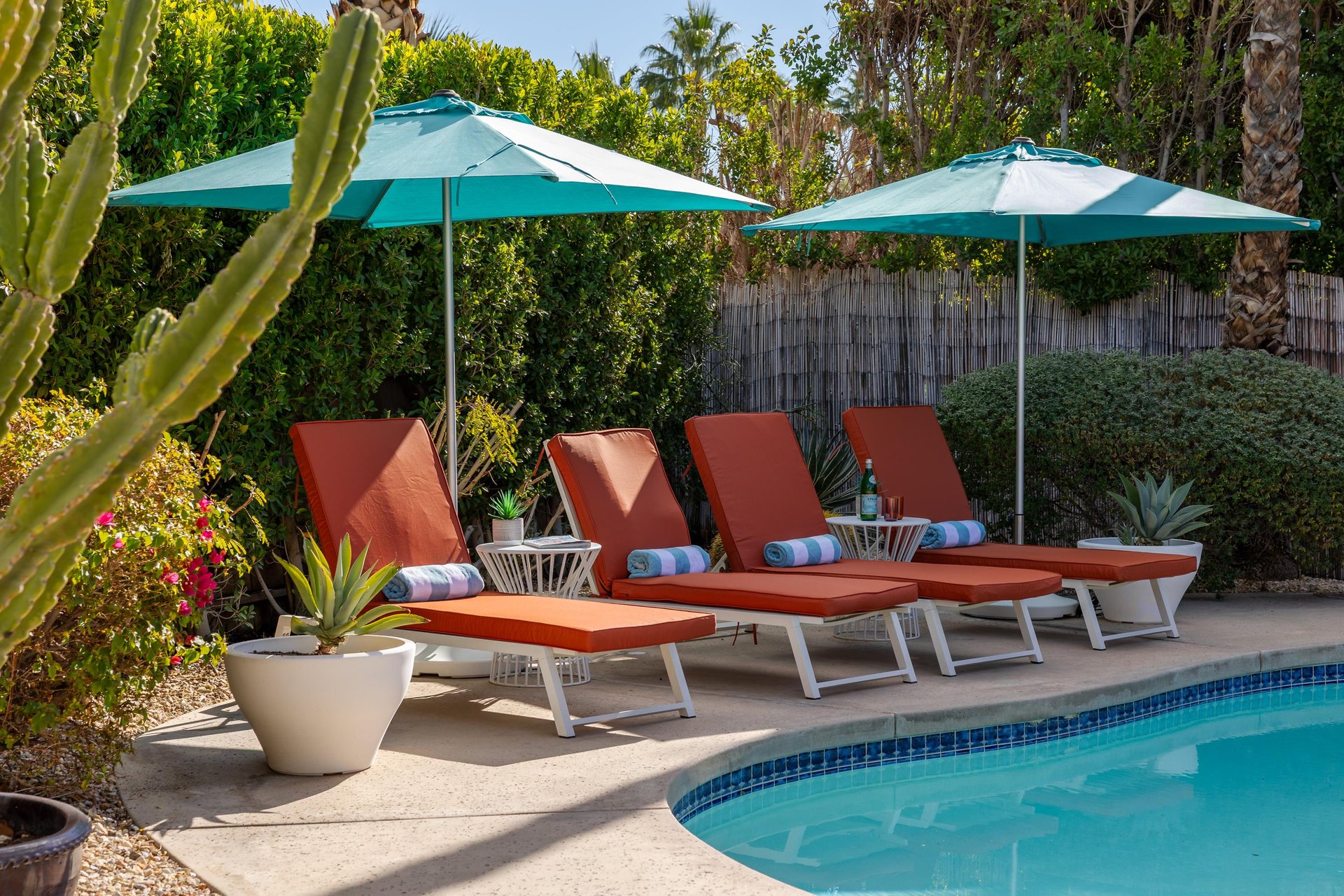Sink into plush poolside loungers under turquoise umbrellas, where tropical gardens and crystalclear waters create your perfect sunny retreat.
