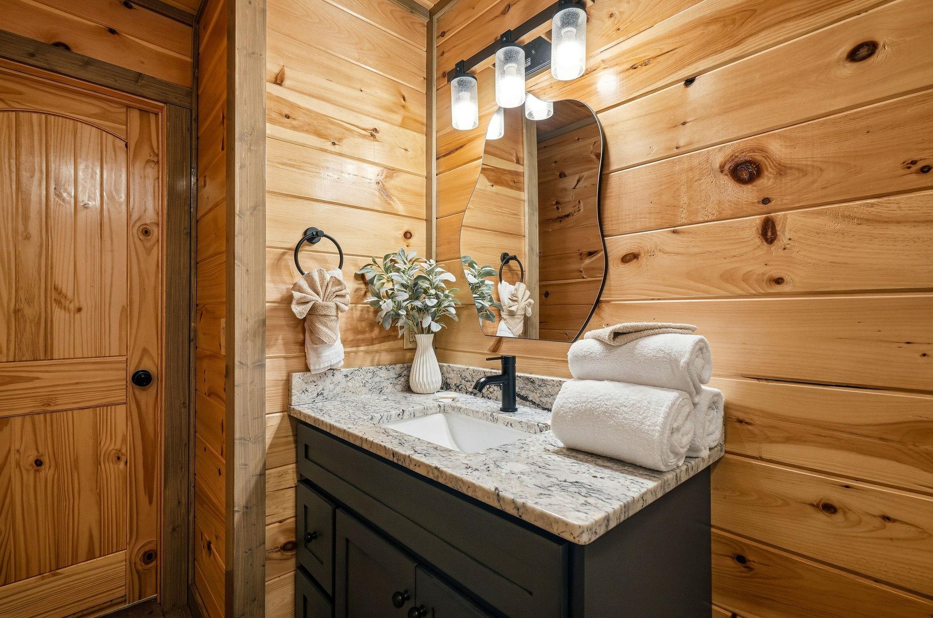Unwind in your rusticchic bathroom featuring warm wood walls, granite counters, and fluffy towels waiting for your arrival.