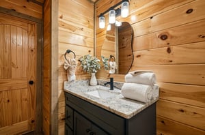 Unwind in your rusticchic bathroom featuring warm wood walls, granite counters, and fluffy towels waiting for your arrival.