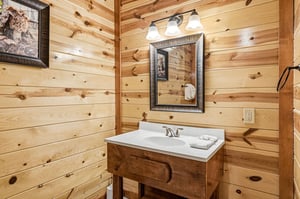 Step into your rustic bathroom sanctuary with warm pine walls, elegant vanity, and thoughtful touches that make you feel right at home.