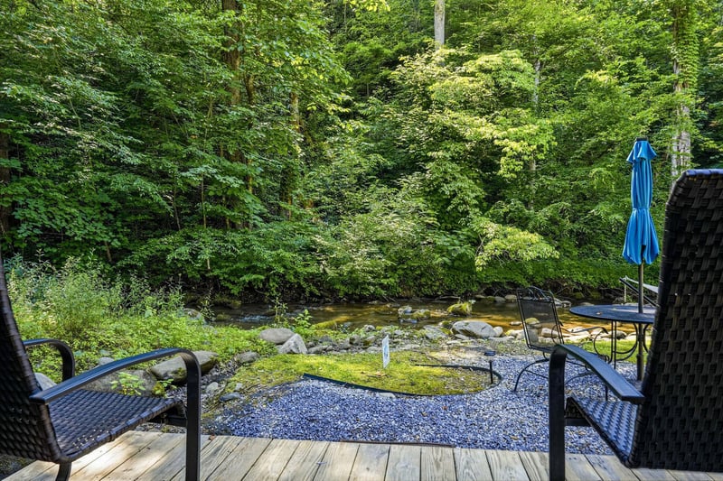 A tranquil stream flows past this peaceful outdoor retreat, where you can unwind in cushioned seating surrounded by lush forest. Listen to the gentle babble of water and breathe in the fresh mountain 