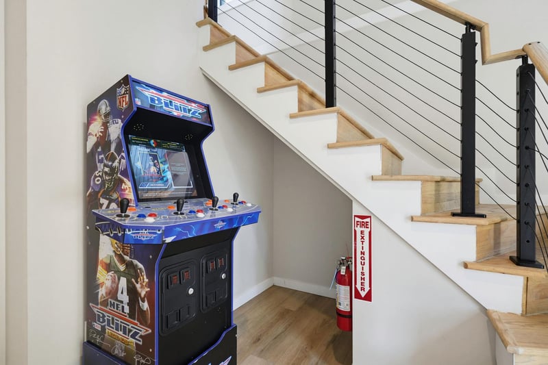A custom arcade machine tucked beneath the stairs brings fun and nostalgia, perfect for unwinding after a day of adventure.