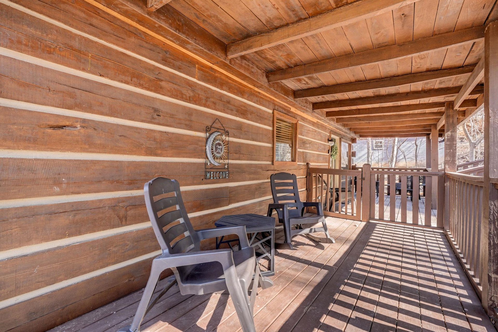 Your private covered deck offers cozy seating where you can unwind with morning coffee or evening conversations surrounded by rustic charm.