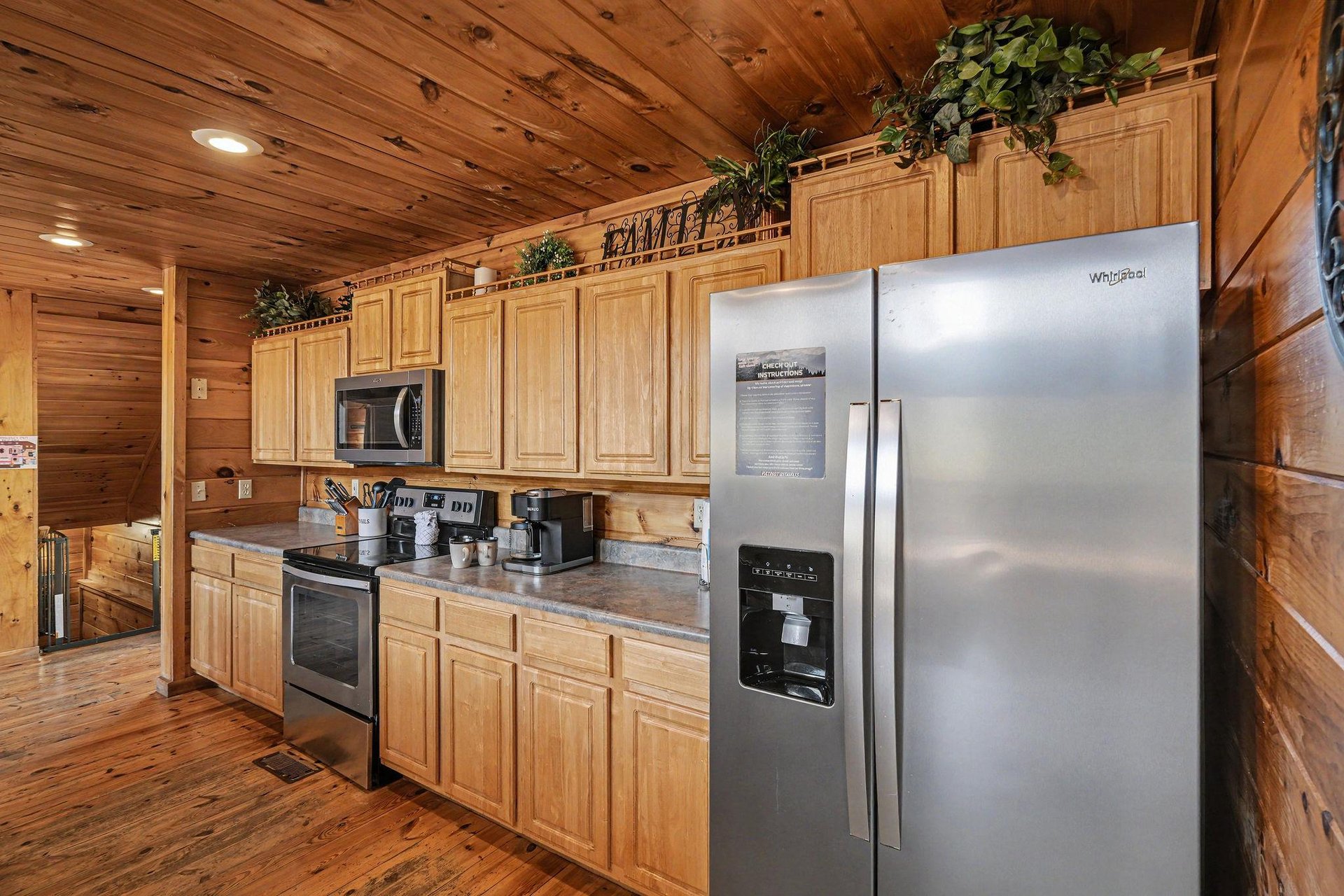 Step into your rustic cabin kitchen with warm wood walls, granite counters, and full appliances ready for your mountain getaway meals.
