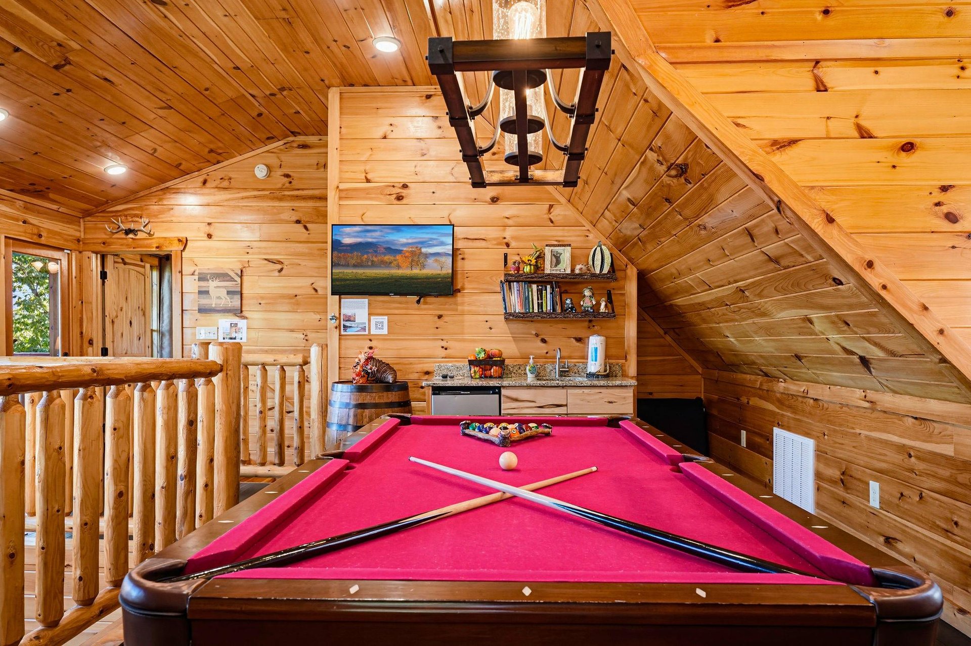 Game on Your loft game room features a fullsize billiards table, kitchenette with sink, and all the rustic cabin charm of knotty pine walls and vaulted ceilings.