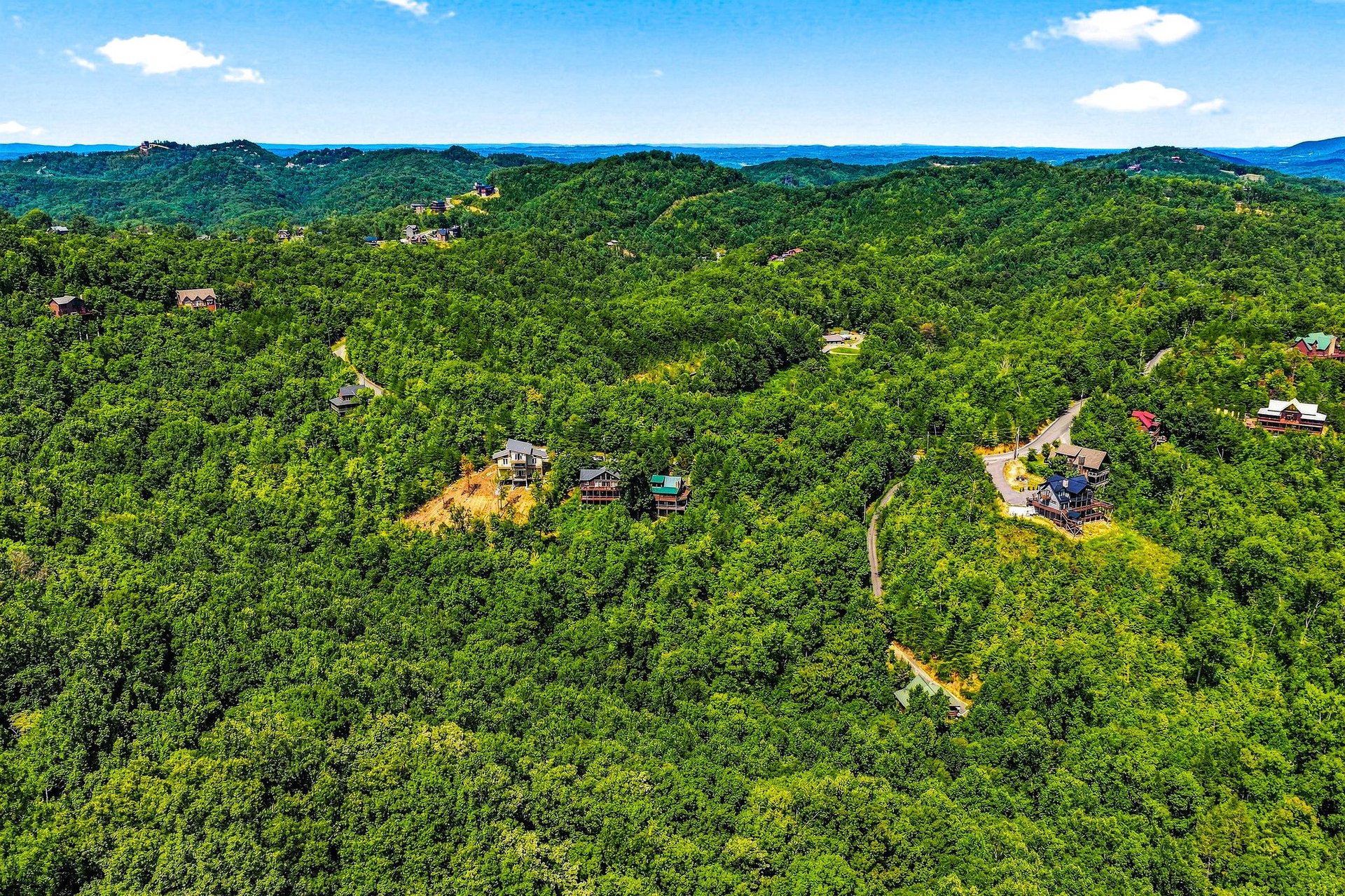 Nestled in lush rolling mountains, the property offers peaceful seclusion among forested hillsides and winding scenic roads in a serene natural setting.