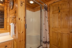 Shower next to a jacuzzi tub at A Lovers Secret, a 1 bedroom cabin rental located in Gatlinburg