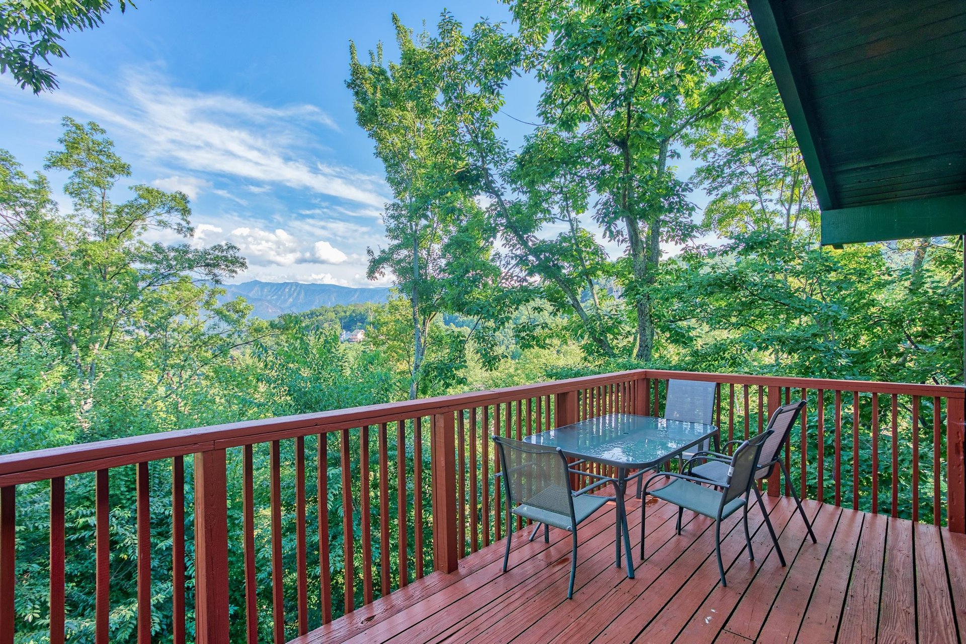 Dining space for four on the deck with mountain views at Bushwood Lodge, a 3bedroom cabin rental located in Gatlinburg