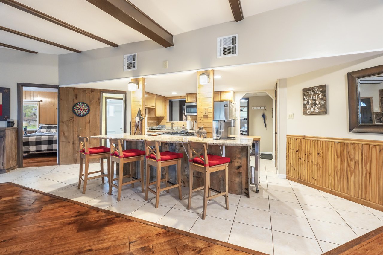 Fully equipped kitchen with counter seating for 4, stainless steel appliances, and cooking essentials.