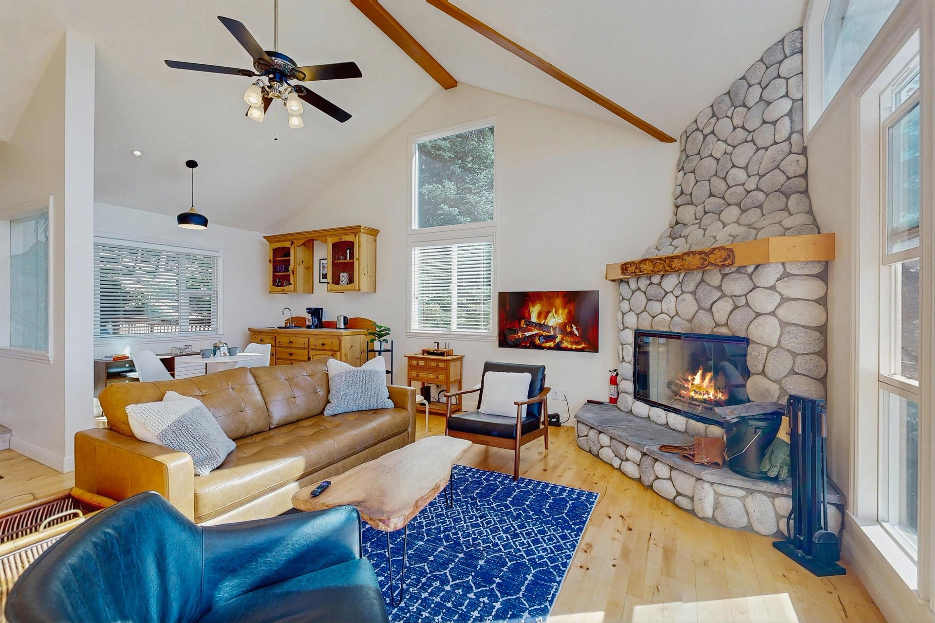 Large stone fireplace, ample seating, and easy access to the kitchen and dining area.