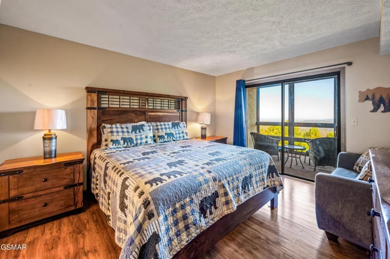 Rustic wooden headboard and forestthemed bedding create your perfect mountain retreat with private balcony overlooking scenic valleys.