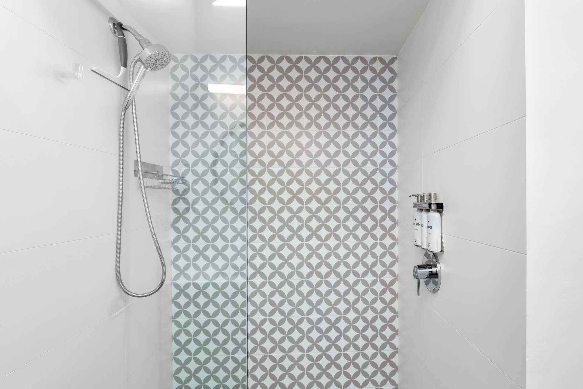 Step into your private spalike shower featuring elegant geometric tiles and a luxurious rainfall showerhead for the perfect start to your morning.