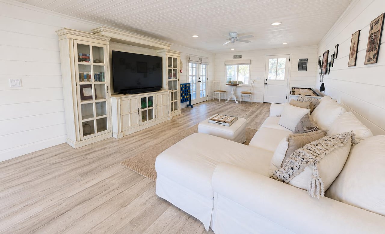 Funfilled game room featuring a Smart TV, shuffleboard, giant Connect Four, board games, and a pullout sofa.