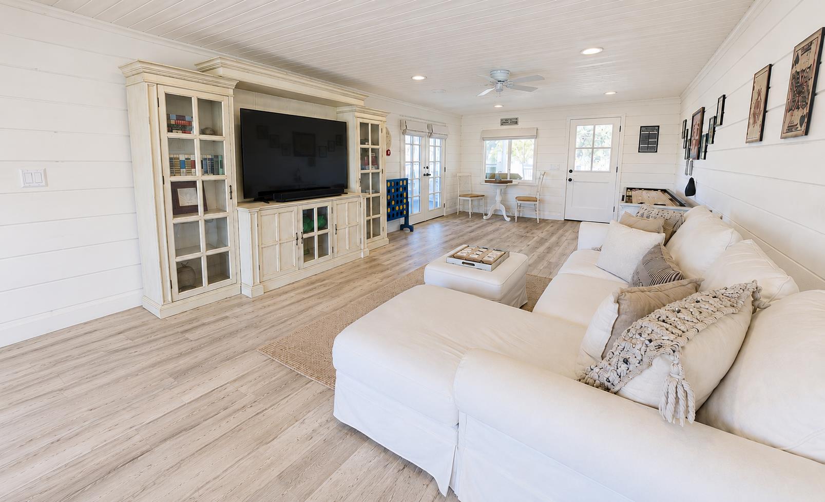 Funfilled game room featuring a Smart TV, shuffleboard, giant Connect Four, board games, and a pullout sofa.