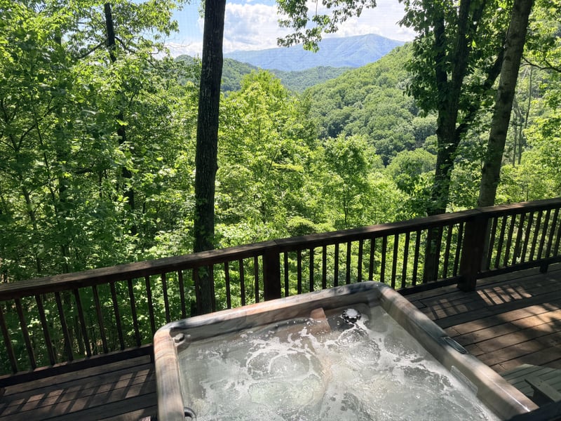 Soak in the bubbling hot tub while gazing at sweeping mountain views through the trees. A perfect spot to unwind and reconnect with nature.