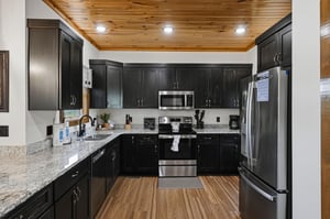Prepare delicious meals in your spacious kitchen with granite countertops, stainless appliances, and warm wood ceiling. Everything you need for a relaxing stay is at your fingertips.