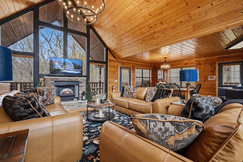 Sink into plush leather seating by your crackling fireplace, where warm wood surrounds you and stunning chandeliers create the perfect mountain retreat atmosphere.