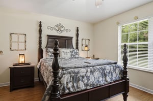 Sink into this elegant fourposter bed adorned with charming farmhouse décor, where soft natural light and rustic touches create your perfect retreat.