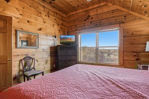 Wake up to panoramic desert views from your cozy log cabin bedroom, where rustic charm meets comfort with handcrafted wooden walls.