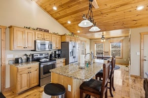 Your fullyequipped kitchen awaits with granite counters, stainless appliances, and rustic wood ceilings—perfect for cooking memorable meals together.